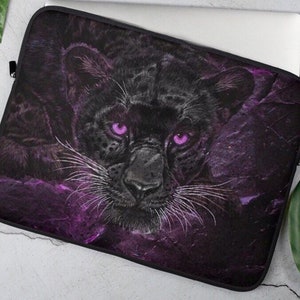 Puede incluir: Funda para portátil de pantera negra con fondo morado y negro. La pantera tiene ojos rosa brillante y bigotes blancos.