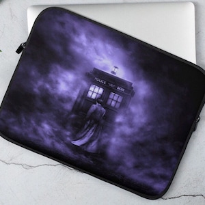 May include: A purple laptop sleeve with a black and white image of a police box, a person in a long coat, and a foggy background. The text "POLICE PUBLIC BOX" is on the police box.