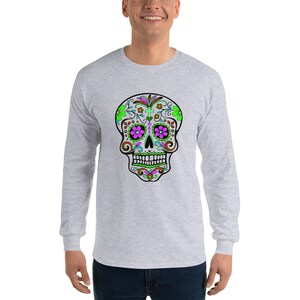 May include: A gray long-sleeve t-shirt with a colorful sugar skull design. The skull is decorated with green, pink, and brown floral patterns.