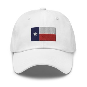 May include: White baseball cap with an embroidered Texas state flag on the front. The flag is blue, white, and red with a single white star in the blue section.