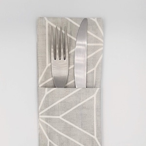 May include: A grey fabric napkin with a white geometric pattern, holding a silver fork and knife.