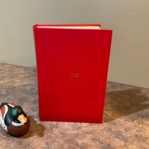 May include: A red hardcover book with the title "WILLIAM SHAKESPEARE" printed in gold on the front cover.