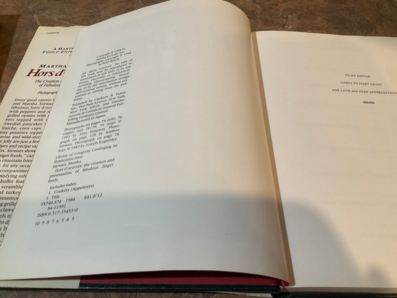 May include: A white book with a red spine and black text on the cover. The title is "Martha Stewart's Hors d'oeuvres: The Creation and Presentation of Fabulous Finger Foods". The book is open to a page with copyright information and a dedication to the editor.