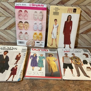 Puede incluir: Cinco patrones de costura diferentes para ropa. Los patrones están en papel blanco con ilustraciones en negro y color. Los patrones incluyen un vestido, una capa, una falda, un pantalón y una camisa. Los patrones son de Simplicity, Burda y McCall's.
