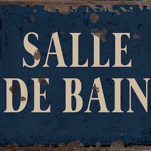 May include: A blue metal sign with white lettering that reads "Salle de Bain". The sign is rusty and has a distressed look.