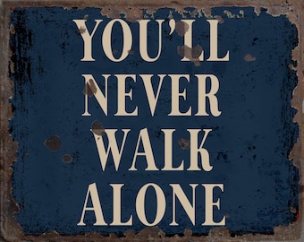 May include: A blue metal sign with the text "You'll Never Walk Alone" in white lettering. The sign has a distressed, rusty look.