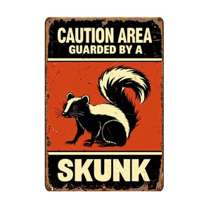 May include: A rectangular metal sign with a distressed finish. The sign features a black and white skunk illustration on an orange background. Text at the top reads "CAUTION AREA GUARDED BY A" and at the bottom "SKUNK."