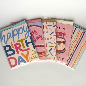 May include: A collection of birthday cards with colorful text and designs. The cards feature phrases like "Happy Birthday to you" and "Have a Sweet Day." The cards have a variety of patterns, including cake illustrations and confetti.