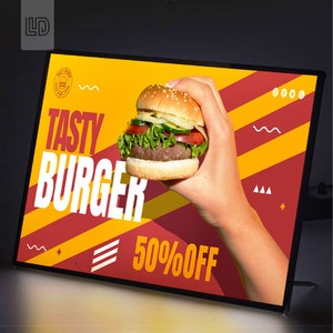 May include: A yellow and red sign with the text "Tasty Burger" and "50% Off" in white. A hand holds a large, juicy burger with lettuce, tomato, and onion.