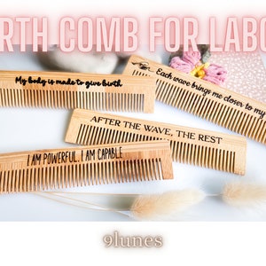 Peut inclure: Plusieurs peignes de naissance en bois avec des citations inspirantes. Les peignes portent des inscriptions gravées telles que "Mon corps est fait pour donner naissance" et "Je suis puissante. Je suis capable." Les peignes sont en bois clair et disposés sur une surface blanche.