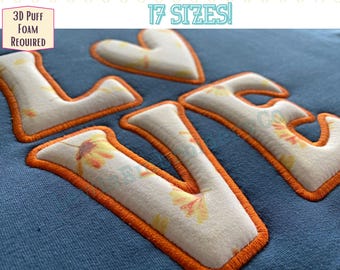 Puede incluir: Primer plano de una tela azul con la palabra "LOVE" bordada en hilo naranja. Las letras están rellenas de una tela blanca con un patrón floral. También se puede ver el texto "3D Puff Foam Required" y "17 SIZES!"