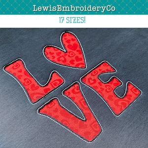 Puede incluir: Bordado rojo "LOVE" con un corazón en el centro y un patrón de pequeños corazones en todo. Las letras están delineadas con hilo blanco. El bordado está sobre una tela gris oscura.