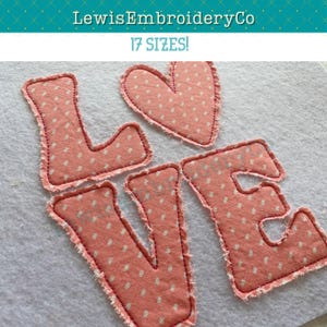 May include: A pink fabric applique of the word "LOVE" with a heart in the middle. The letters and heart have a white polka dot pattern and are outlined in red thread.