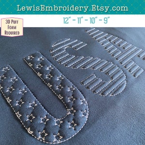 Puede incluir: Diseño bordado "USA" en hilo blanco sobre una tela azul oscuro. Las letras están bordeadas de estrellas y la "A" está llena de líneas horizontales. El diseño está disponible en tamaños de 9 a 12 pulgadas.