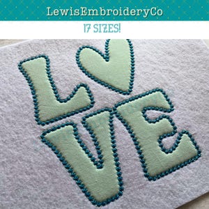 May include: A light green embroidered design of the word "LOVE" with a heart in place of the "O". The letters are outlined in teal.