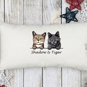 May include: A white pillow with a brown and black cat and a gray cat peeking over the top. The text "Shadow & Tiger" is printed below the cats.