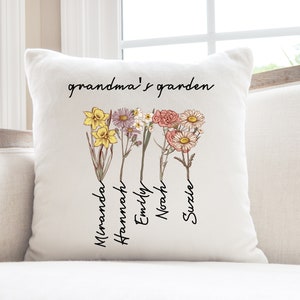 May include: Cream-colored square throw pillow with the text "grandma's garden" in black script. Below the text are illustrations of colorful flowers with names: Miranda, Hannah, Emily, Noah, and Suzle.