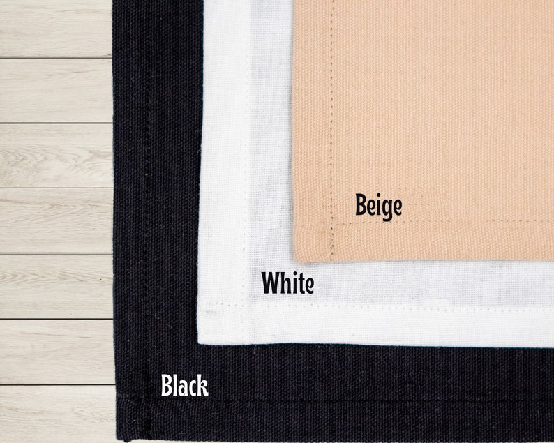 May include: Close-up of three fabric swatches in black, white, and beige. The word "Black" is printed on the black swatch, "White" on the white swatch, and "Beige" on the beige swatch. The fabrics appear to be canvas or a similar material.