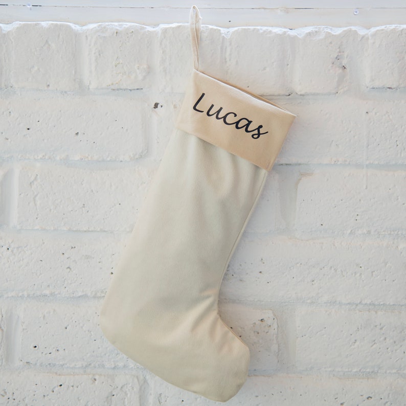 May include: A white Christmas stocking with the name "Lucas" embroidered on the cuff.