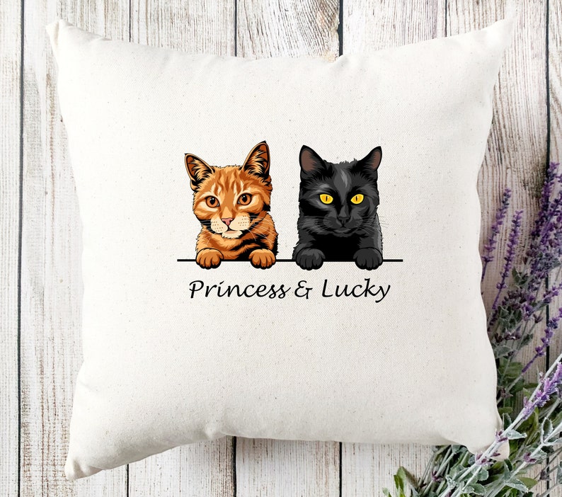May include: White pillow with a black cat and an orange tabby cat peeking over the top. The text "Princess & Lucky" is printed below the cats.