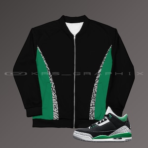 Puede incluir: Chaqueta bomber negra y verde con cierre de cremallera y un par de zapatillas negras y verdes con suela blanca.