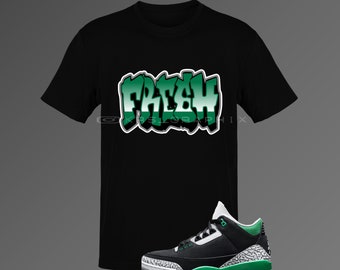May include: Black t-shirt with a green "FRESH" graphic and a pair of black and green sneakers with white accents.