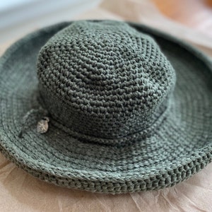 A green crocheted sun hat with a wide brim
