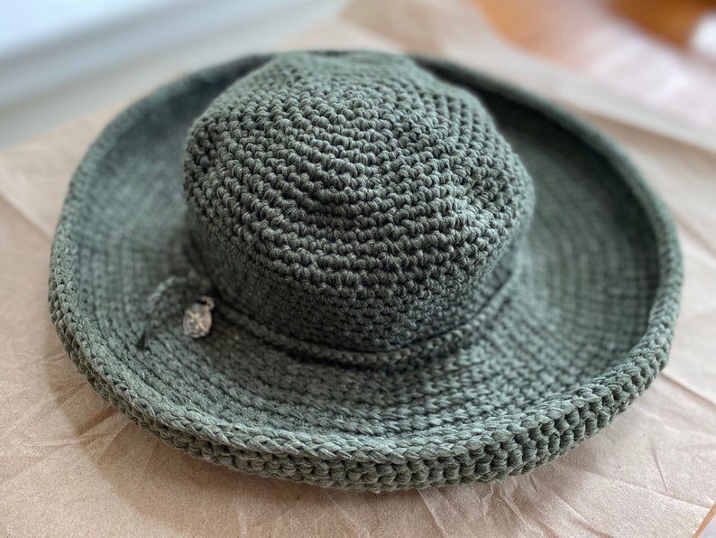 A green crocheted sun hat with a wide brim