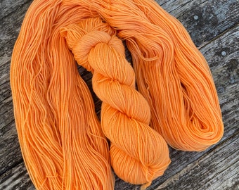 Tangerine fingering SW Merino high twist hand dyed yarn. 2-ply indie dyed sock yarn.