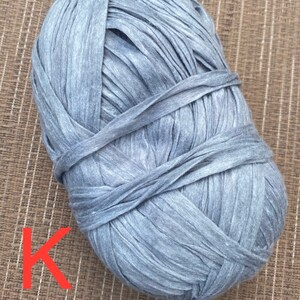 Puede incluir: Un ovillo de hilo gris hecho de camisetas recicladas. El hilo es grueso y texturizado, perfecto para tejer o hacer crochet.