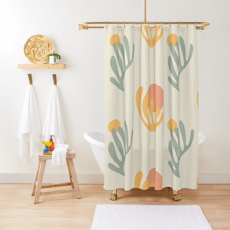May include: A shower curtain with a cream background and a repeating pattern of stylized green leaves and yellow and orange flowers.