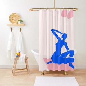 May include: A shower curtain with a pink and white background featuring a blue silhouette of a person sitting on a pink cushion.