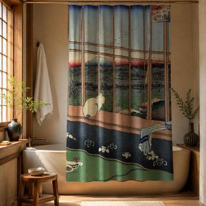 May include: A shower curtain featuring a Japanese woodblock print style illustration of a white cat sitting on a ledge overlooking a landscape with a mountain in the distance, framed by vertical window panes and blue, green, and brown tones.