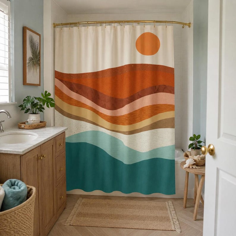 May include: A shower curtain featuring a landscape print with horizontal wavy bands of orange, terracotta, beige, and teal. A solid orange circle representing the sun is positioned in the upper right corner against a cream-colored background.