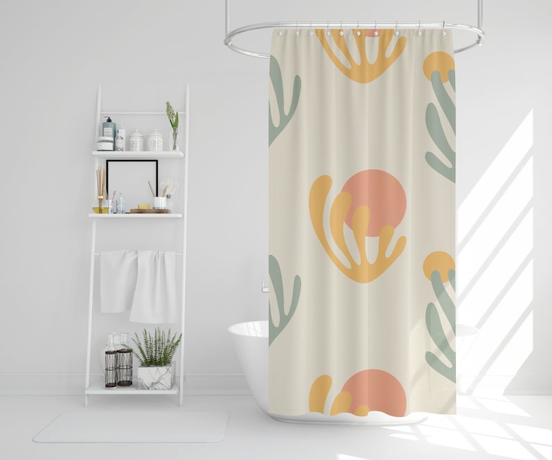 May include: A white shower curtain with a pattern of abstract shapes in shades of yellow, orange, and green. The shapes resemble stylized coral or seaweed.