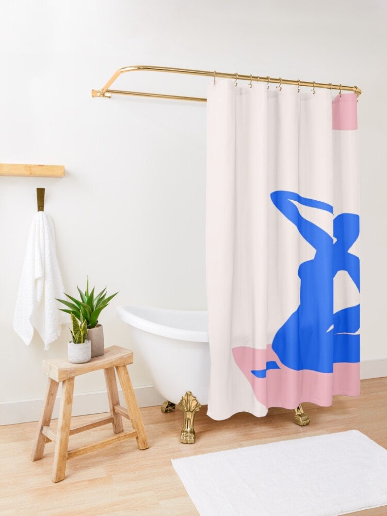 May include: A shower curtain with a pink and blue abstract design. The design features a blue silhouette of a person sitting on a pink surface.