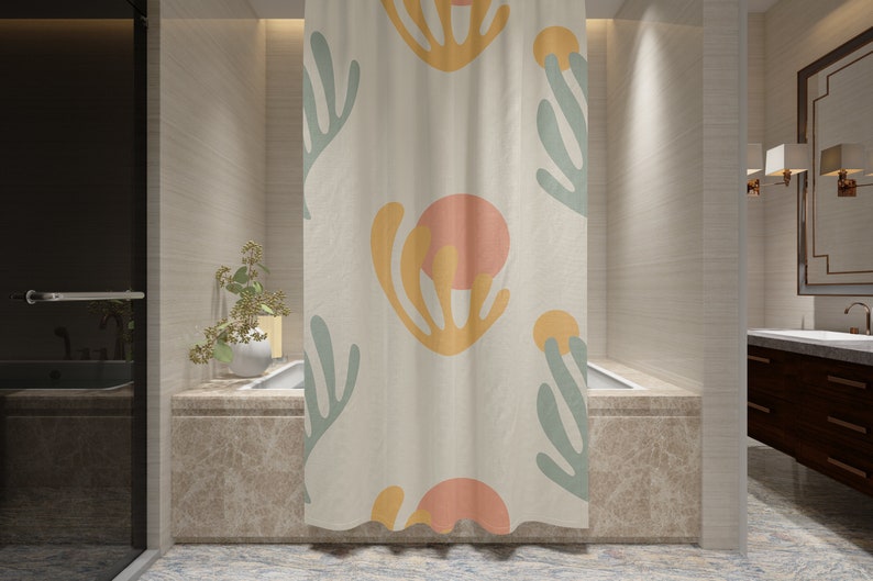 May include: A shower curtain with a white background and a repeating pattern of abstract shapes in shades of yellow, orange, and green.