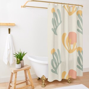 May include: A shower curtain with a cream background and a repeating pattern of abstract shapes in shades of yellow, pink, and green.