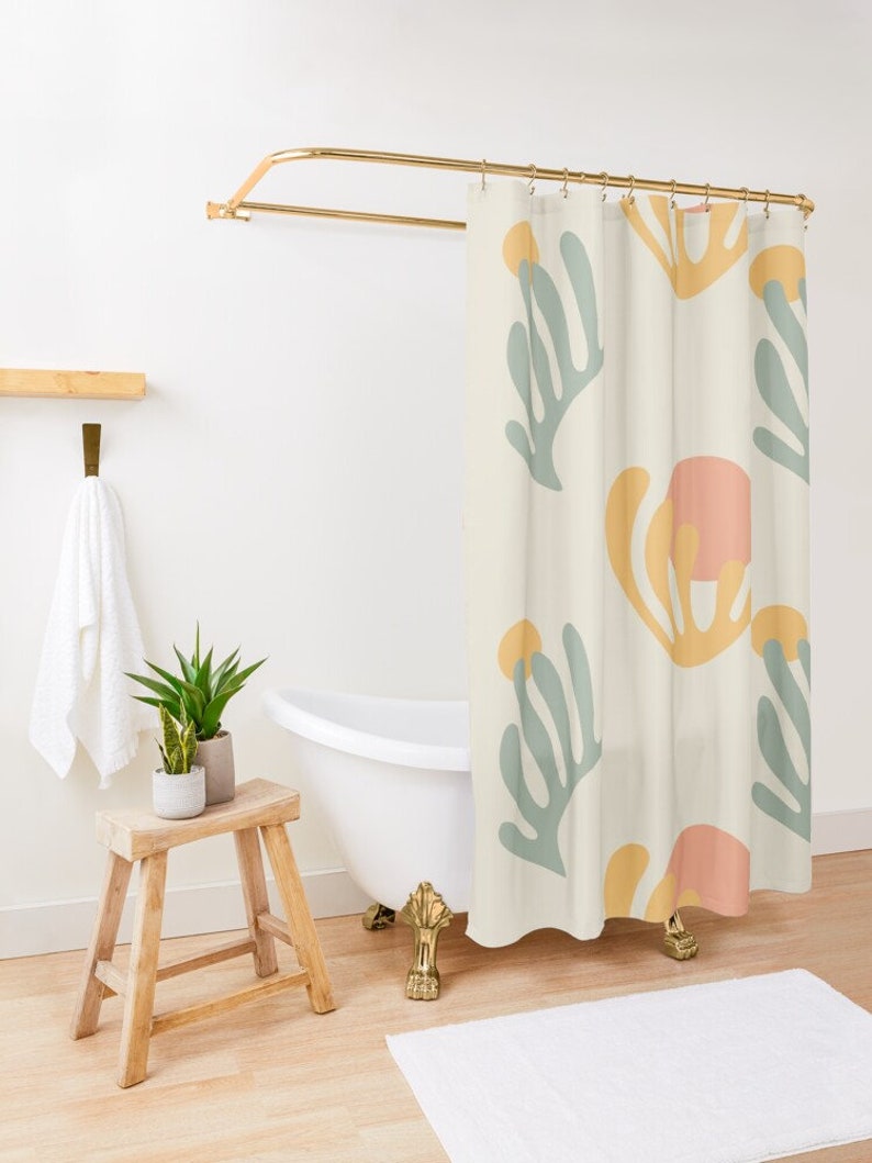 May include: A shower curtain with a cream background and a repeating pattern of abstract shapes in shades of yellow, pink, and green.