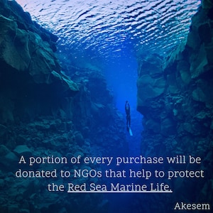 May include: A diver explores a deep underwater crevice in shades of blue. The image includes the text: "A portion of every purchase will be donated to NGOs that help to protect the Red Sea Marine Life."