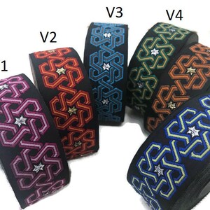 May include: Six different colours of woven ribbon with a geometric pattern. The ribbon is black with a silver star pattern and is available in pink, orange, blue, green, brown, and light blue.
