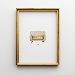 Könnte beinhalten: Ein gerahmter Druck mit einer Aquarellillustration eines beigefarbenen Sessels mit Knopfdetails. Das Kunstwerk ist vor einem weißen Hintergrund platziert und in einem goldfarbenen Rahmen eingefasst. Das Wort "pivot" ist darunter gedruckt.