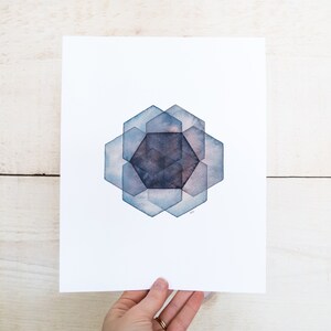 May include: A watercolor painting of a geometric design with overlapping hexagons in shades of blue and gray.