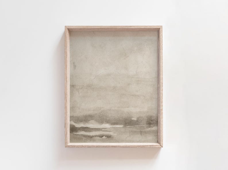 May include: A framed abstract art print with a neutral color palette. The artwork features a watercolor-style landscape with soft, muted tones of beige, gray, and brown. The wooden frame adds a natural touch to the minimalist design.