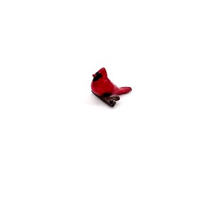 Puede incluir: Una figurita de cardenal rojo posada en una rama, una opci&oacute;n popular para la decoraci&oacute;n del hogar y los amantes de las aves.