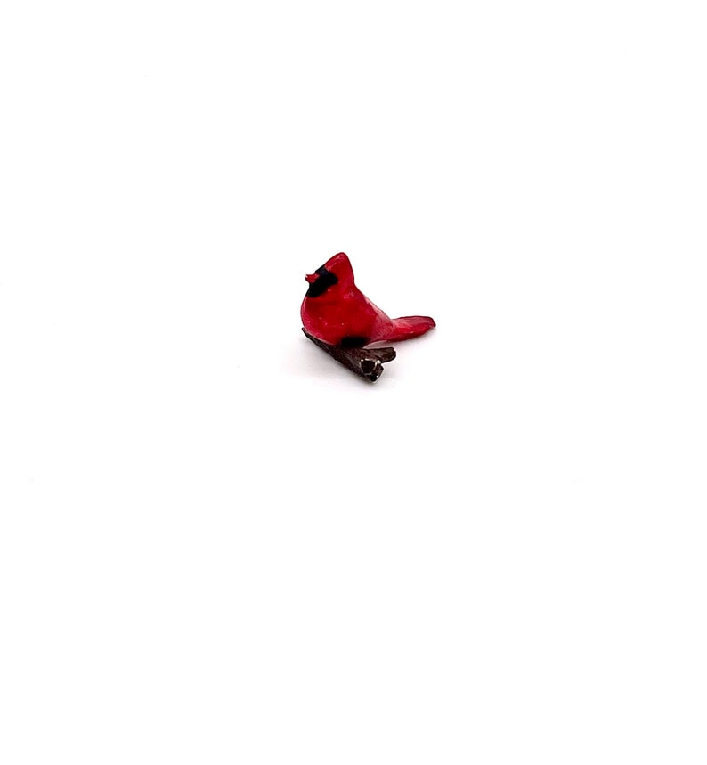 Puede incluir: Una figurita de cardenal rojo posada en una rama, una opci&oacute;n popular para la decoraci&oacute;n del hogar y los amantes de las aves.