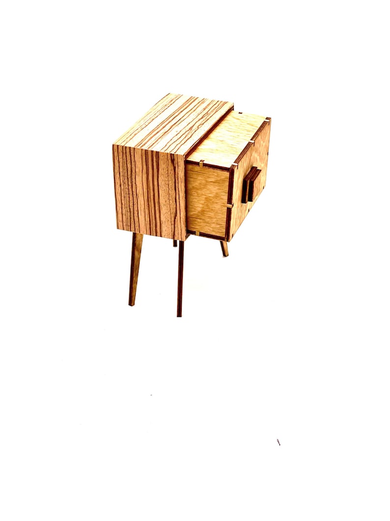May include: A small, wooden nightstand with a mid-century modern design. The nightstand features a drawer and a cabinet, with a light wood finish and dark wood legs. The top of the nightstand has a striped pattern.