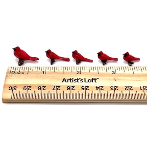 Puede incluir: Cinco figuritas de cardenal rojo en miniatura alineadas en una regla de madera. La regla est&aacute; marcada en pulgadas y tiene el texto "Artist's Loft" impreso en ella.