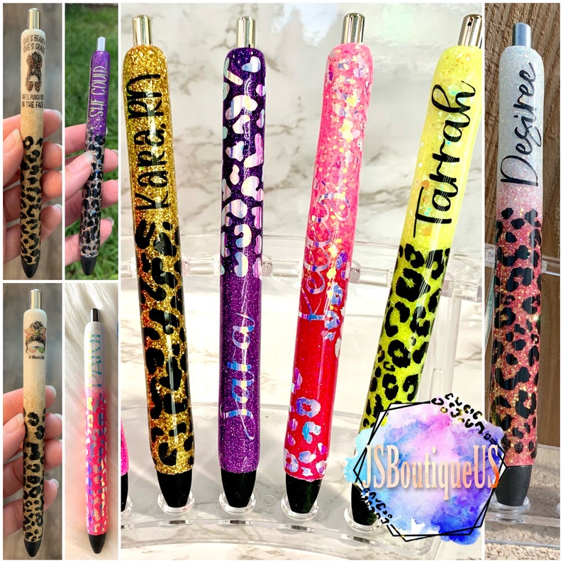 May include: A set of ten personalized pens with glitter and leopard print designs. The pens are decorated with names such as "Julia", "Kara", "Tatrha", and "Desire".