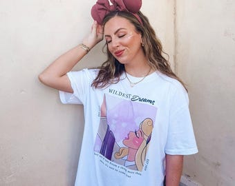 May include: White t-shirt with a graphic of Sleeping Beauty and the text "Wildest Dreams" and "They say if you dream a thing more than once, it's sure to come true".